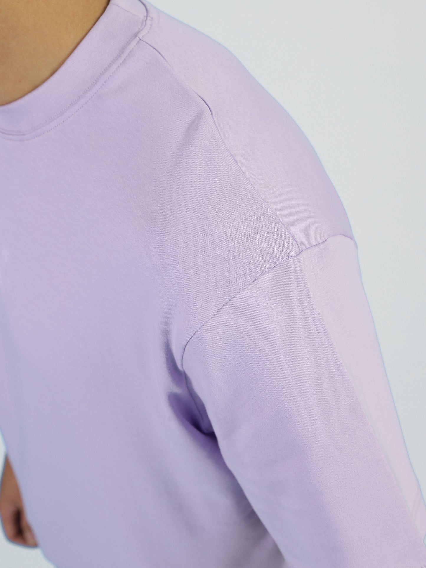 A close-up of a person wearing the My Store Vibe T- Lilac Breeze for men, captured from shoulder to elbow against a plain light background. The premium cotton tee’s lilac shade is shown; the persons face is not visible.