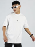 A modern trailblazer stands against a light gray background, wearing white sunglasses, black pants, a black watch, and the My Store Vibe T- Bright White - Men made from premium cotton blend with a small center logo.