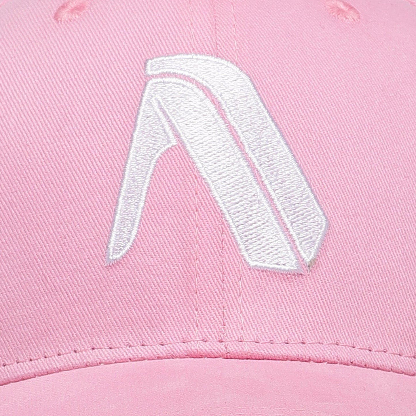 Close-up of the Apex Premium Cotton Cap in pink by My Store, showcasing a white, stylized embroidered angular A logo on the front—crafted from quality cotton, it’s a statement of urban elegance.