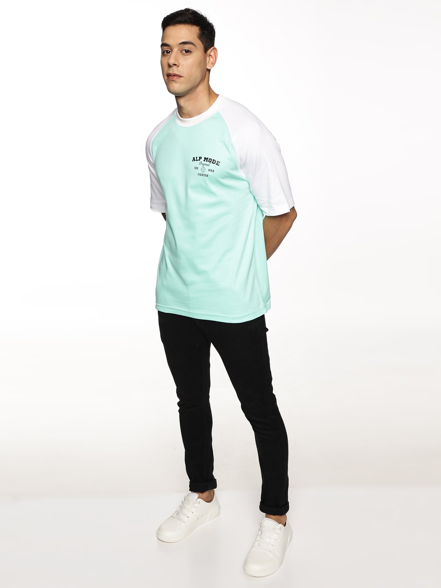 Lifestyle shot of ALP Mode Green Raglan T-Shirt paired with joggers