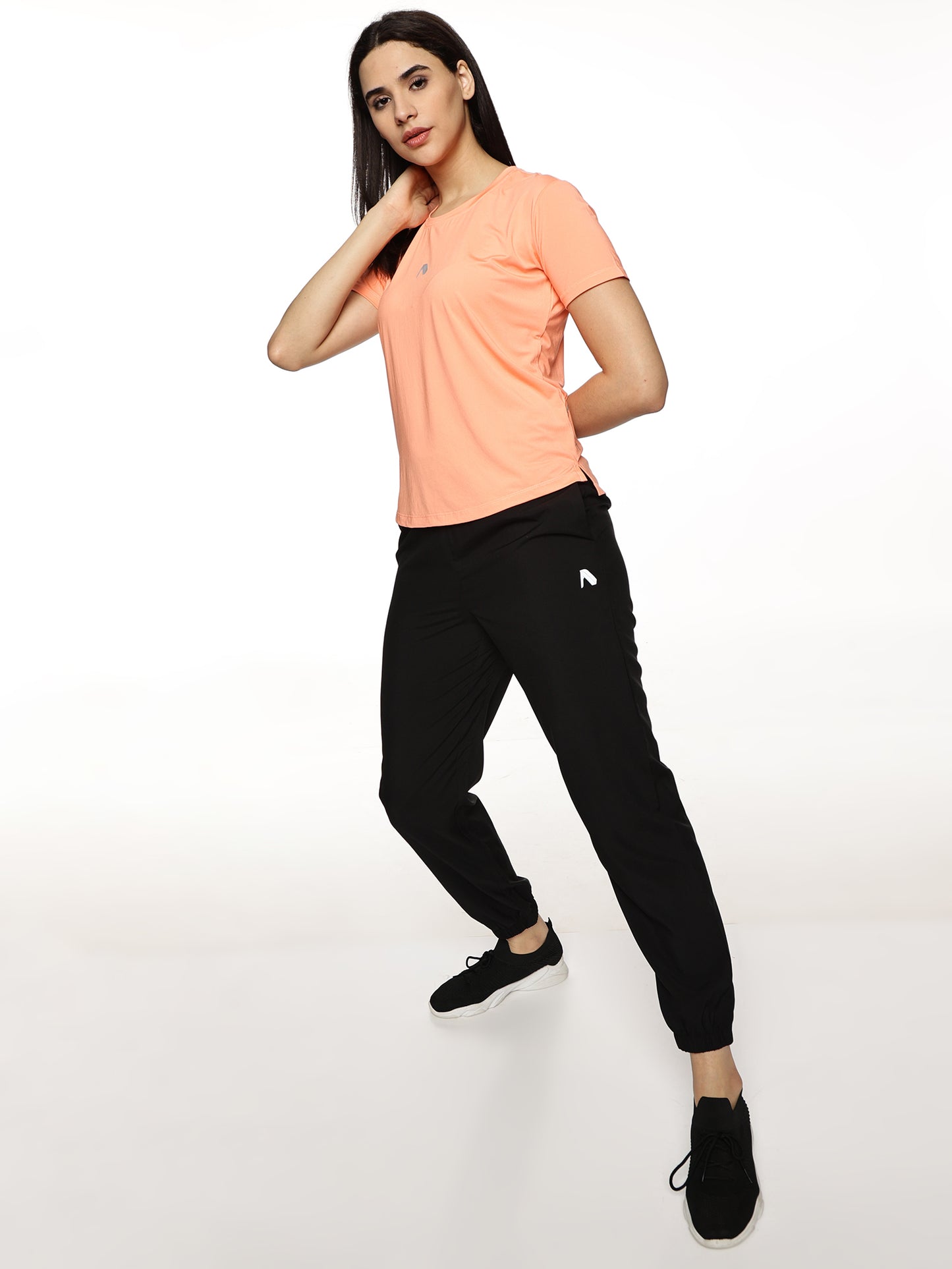 Lifestyle shot of ALP Mode Salmon Pink Performance T-Shirt paired with leggings