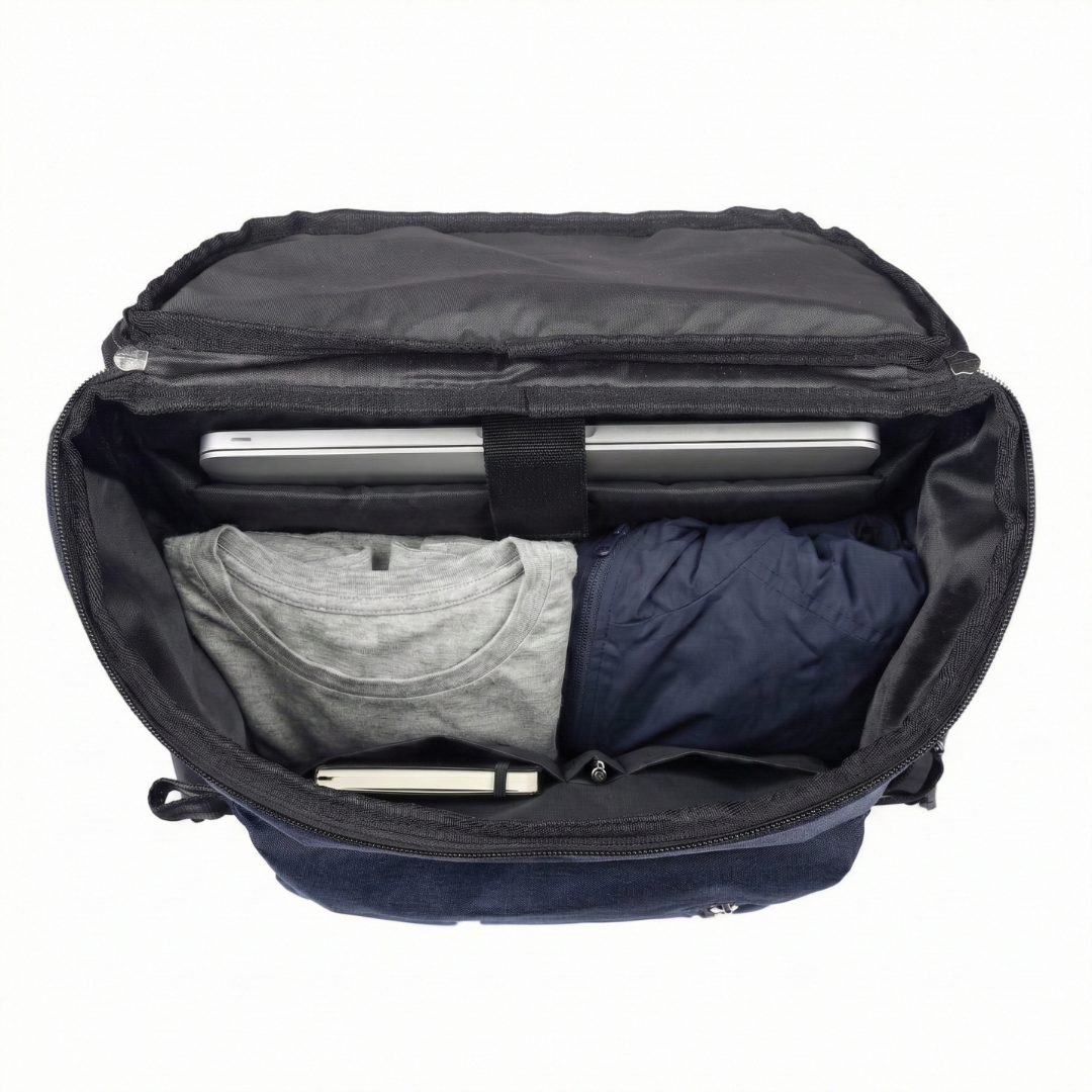 Open black backpack with clothes and a laptop inside on a white background