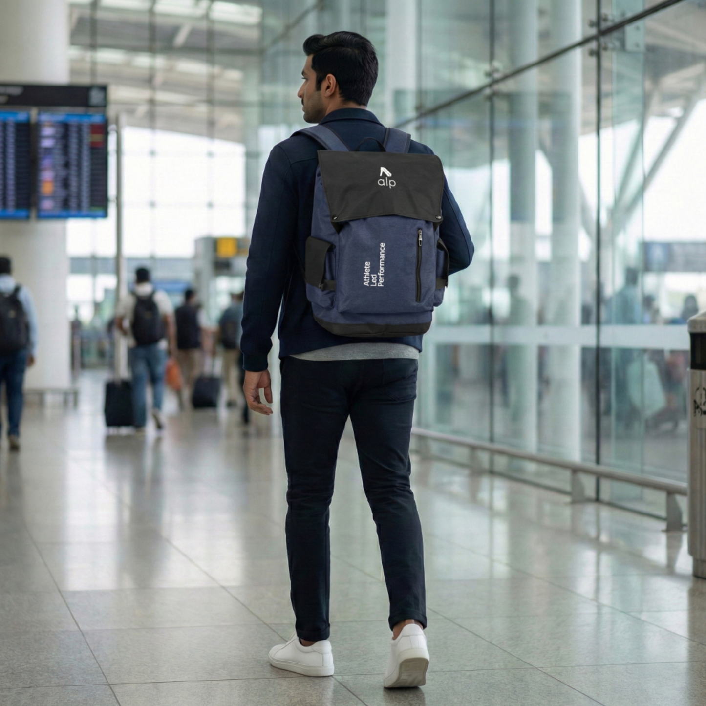 Man walking in an airport with a branded backpack