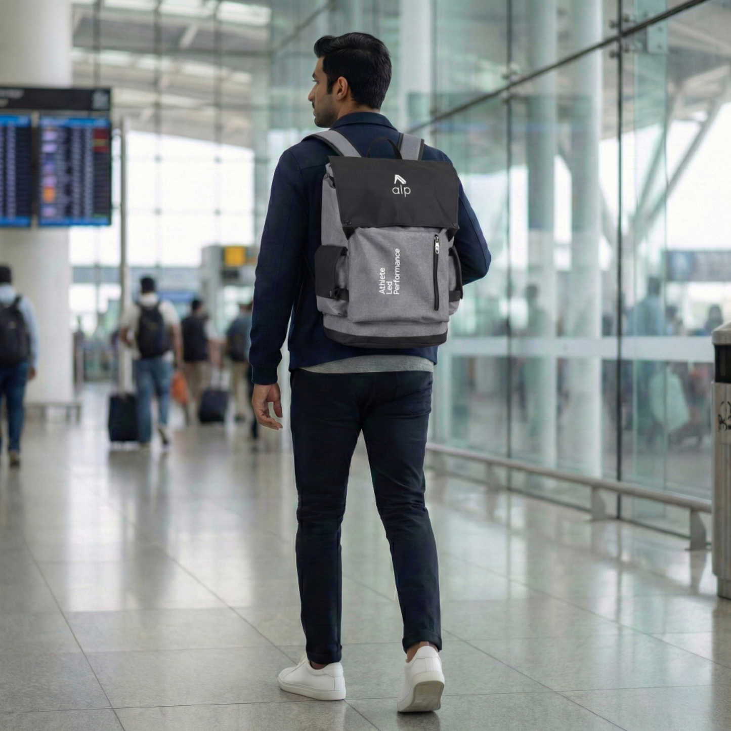 Man with a backpack walking through an airport terminal
