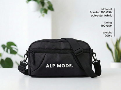 Black bag with 'ALP MODE.' branding on a white surface with plants in the background